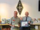 ARRL Wyoming Section Manager Jack Mitchell, N7MJ (left), presented a $1000 check to ARRL CEO David Sumner, K1ZZ, on behalf of the Shy-Wy Amateur Radio Club. Sumner gave Mitchell a certificate of appreciation for the club. [Sean Kutzko, KX9X, photo]